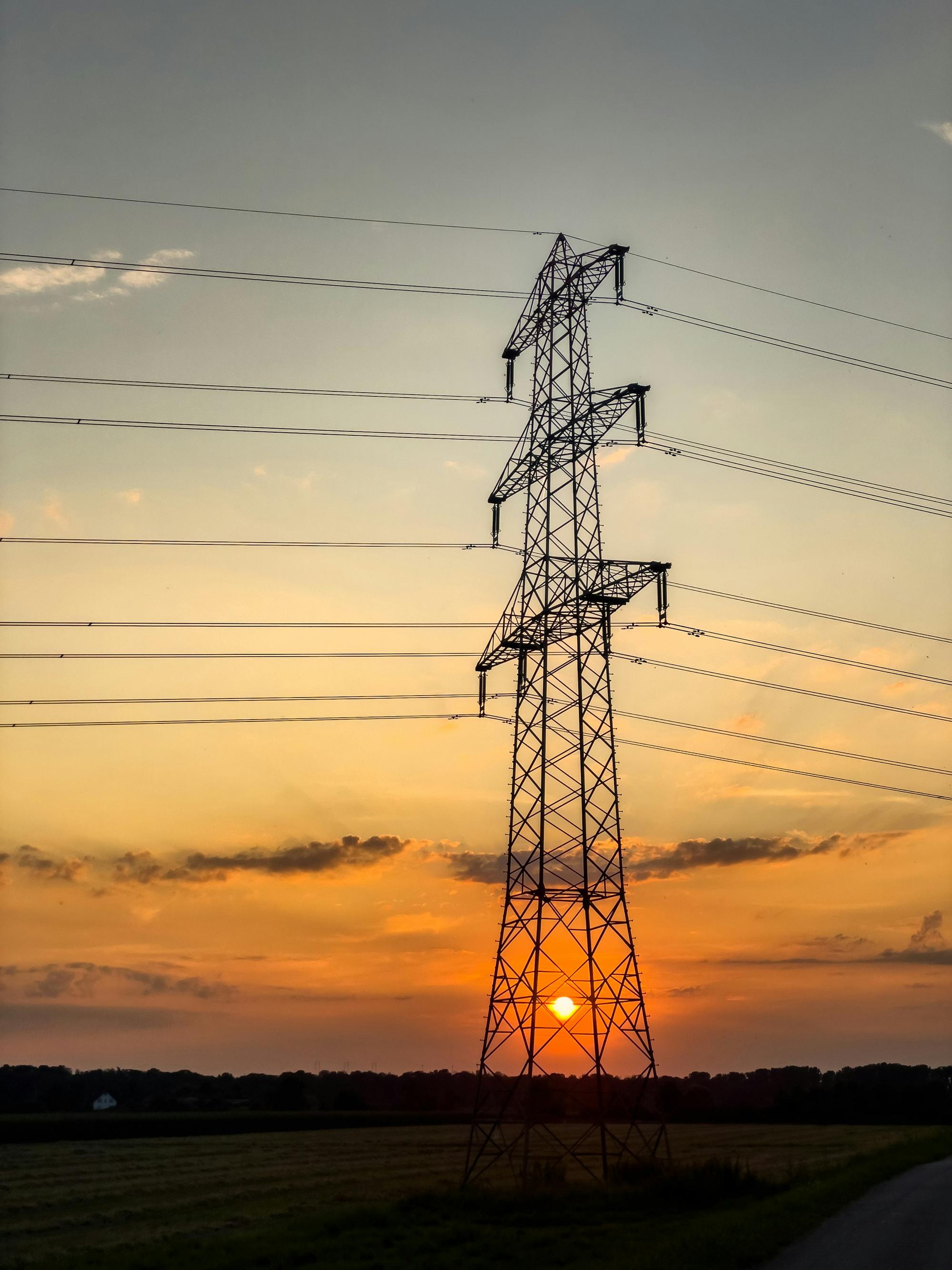 A transmission tower against a golden evening sky